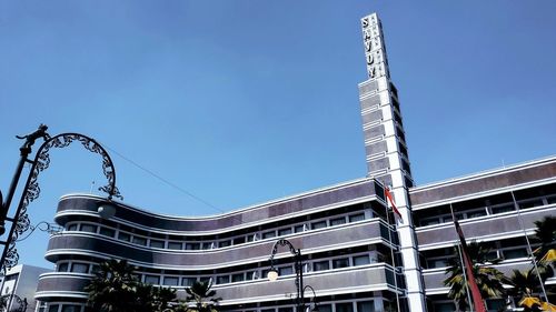 Low angle view of modern building against clear blue sky