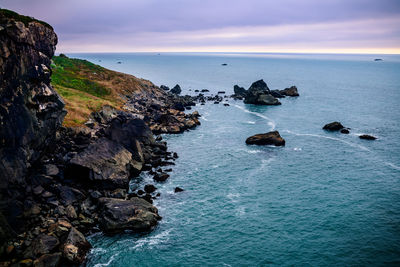 Scenic view of rocks in sea against sky