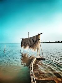 Wooden post in sea against clear sky