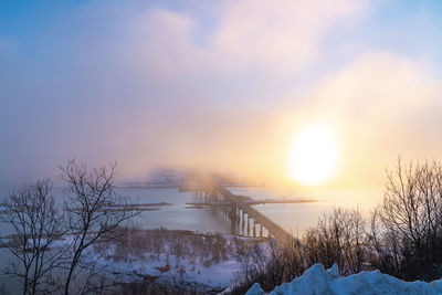 Bridge over river against sky during sunset