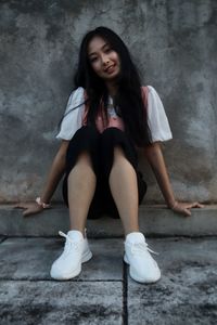 Portrait of a smiling young woman sitting outdoors