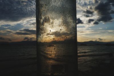 Close-up of metal poles in sea against sky