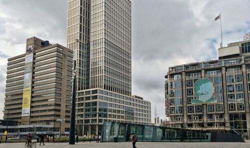 Buildings in city against cloudy sky