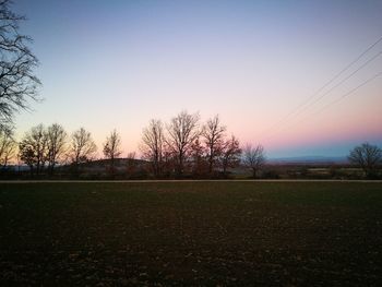 Scenic view of field against clear sky during sunset