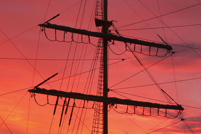 Silhouette electricity pylon against sky during sunset