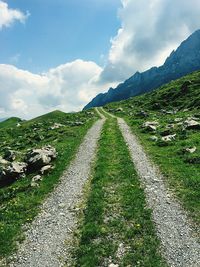 Road amidst agricultural field against sky