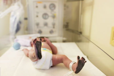 Newborn baby boy with messy feet lying in hospital