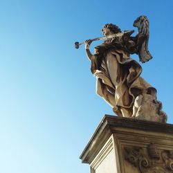 Low angle view of statue against clear blue sky