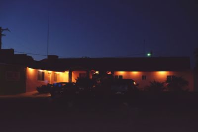 Illuminated city against clear sky at night