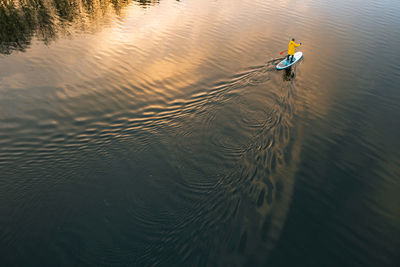 Man sup surfer on the river in winter on sup