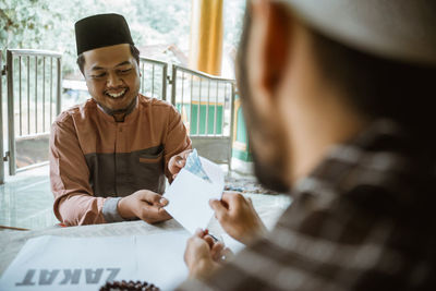 Young man doing charitable donation at mosque