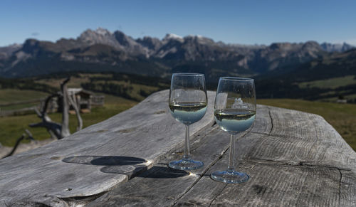 Close-up of beer glass on table against mountain range