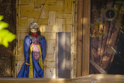 Side view of man standing against wall