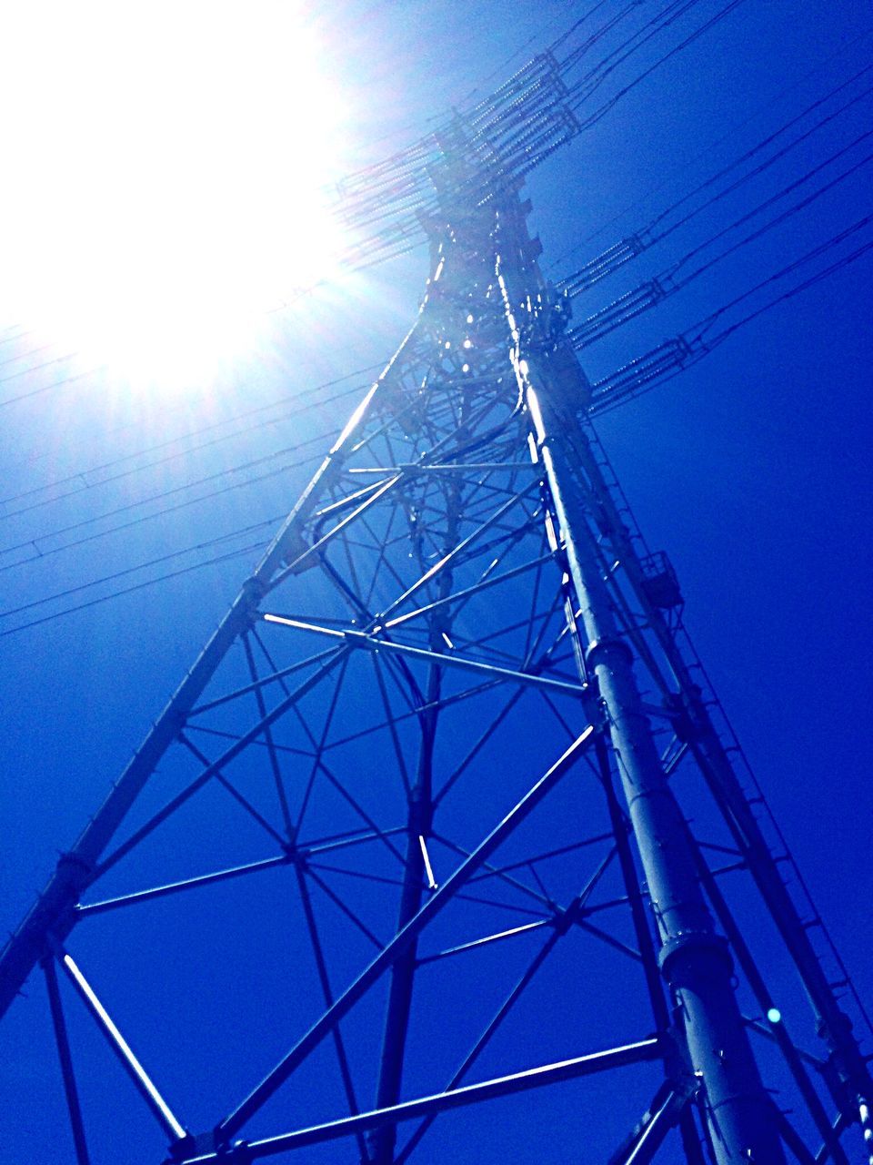 low angle view, blue, connection, power line, electricity, clear sky, sky, cable, electricity pylon, power supply, sunlight, sun, transportation, technology, day, fuel and power generation, outdoors, no people, part of, mast