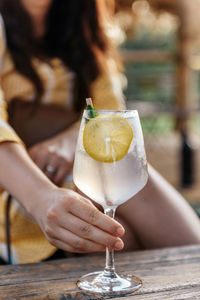 Close-up photo of refreshing lemonade in wine glass on table in beach bar