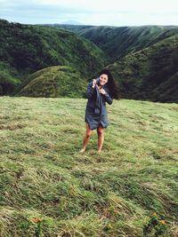 Happy young woman standing on field