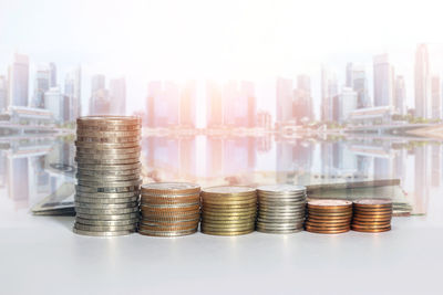 Group of a row of stack money coins on the blurred cityscape background