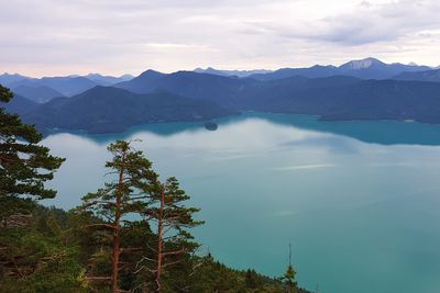 Scenic view of lake by mountains against sky