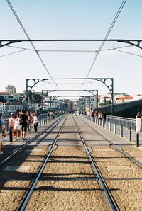 People on railroad station platform against clear sky