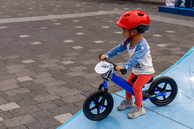 Cute boy sitting on bicycle outdoors