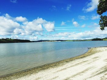 View of calm beach against blue sky