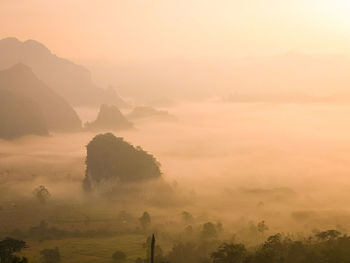 Scenic view of landscape against sky at foggy weather