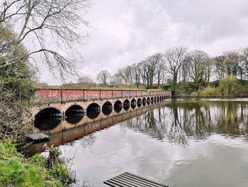Arch bridge over river against sky