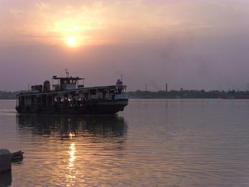 Ship sailing on sea against sky during sunset