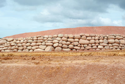 Stack of rocks on field against sky