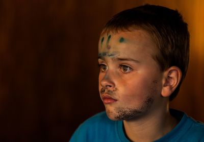Close-up of boy with face paint looking away