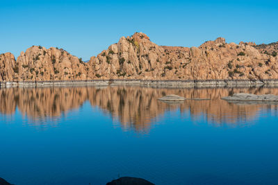 Scenic view of lake and mountains against blue sky