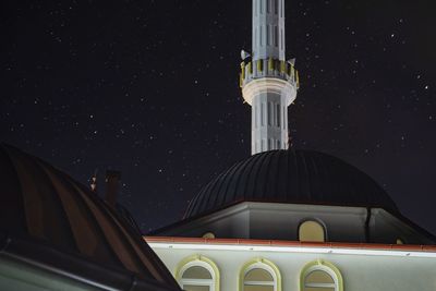 Low angle view of illuminated building against sky at night