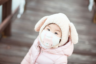 Close-up portrait of girl wearing mask during winter