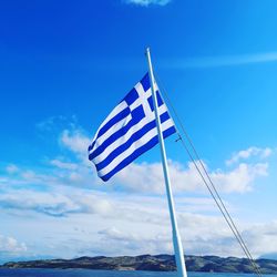 Low angle view of flag against blue sky