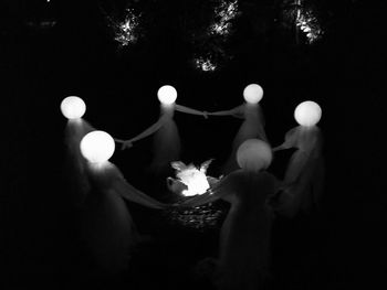 Close-up of hands against sky at night