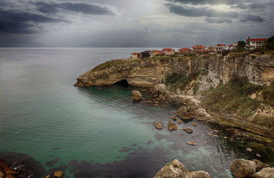 Rock formations by sea against sky