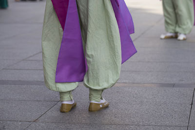 Low section of woman standing on sidewalk