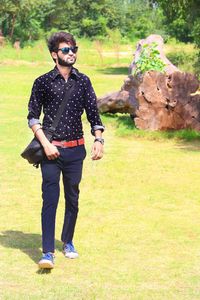 Full length of young man wearing sunglasses standing on land