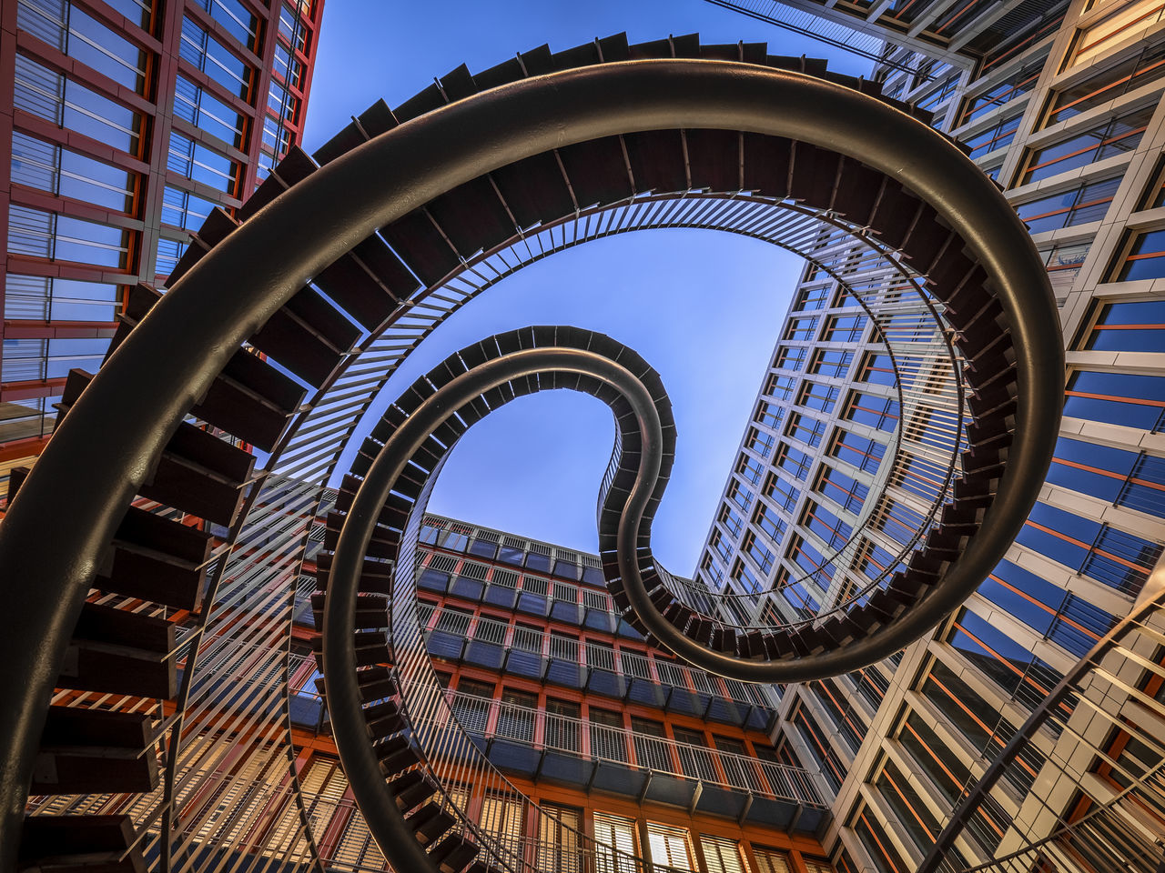 built structure, architecture, low angle view, building exterior, building, sky, pattern, day, no people, modern, city, nature, sunlight, blue, travel destinations, outdoors, glass - material, tall - high, architectural feature, clear sky, office building exterior, skyscraper, directly below