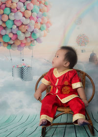 Cute girl sitting on balloons