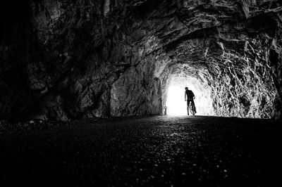 Rear view of man cycling in tunnel
