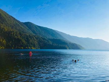 People in lake against mountains