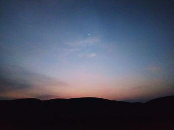 Scenic view of silhouette mountains against sky at sunset