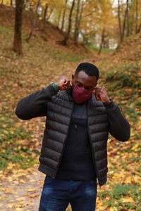 Full length of young man standing in forest