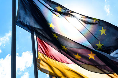 Low angle view of flags against blue sky