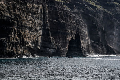 Scenic view of sea by rock formation