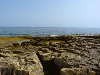 Rocks on beach against clear sky