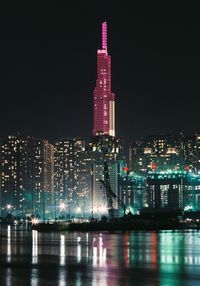 Illuminated buildings against sky at night