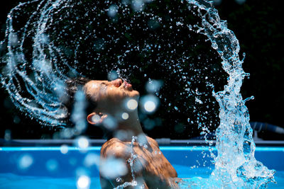 Close-up of woman splashing water