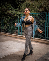 Full length portrait of young woman standing in park